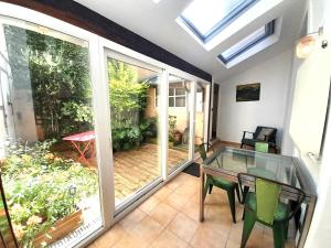 a conservatory with a glass table and chairs and a patio at Belle Maison centrale 8 pers- patio- wifi in Châteauroux