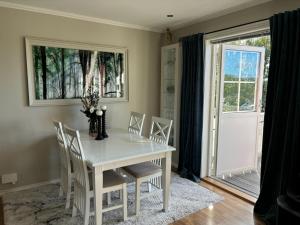 a dining room with a white table and chairs at Konglefaret - apartment in Hønefoss in Hønefoss