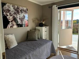 a bedroom with a bed and a large painting on the wall at Konglefaret - apartment in Hønefoss in Hønefoss