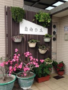 un grupo de plantas en macetas en una valla con flores en 自由之丘民宿, en Taitung