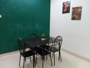 a black table with chairs and a green wall at Bayan Homestay Bayan Lepas Penang in Bayan Lepas +12 photos