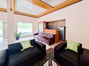 KejajarにあるRedDoorz Syariah near Jalan Dieng 6のリビングルーム(革張りのソファ2台、ピアノ付)