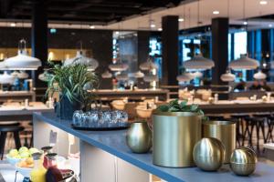 a restaurant with gold vases on a blue counter at Clarion Hotel Air in Sola