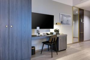 a room with a desk with a chair and a television at Clarion Hotel Air in Sola