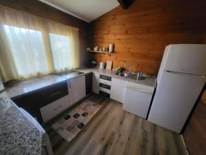 a kitchen with a white refrigerator and wooden walls at Casa Madera Urbanizacion Socorro in Seville