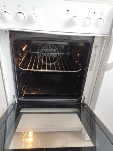 an oven with its door open in a kitchen at Kleine Wohlfühloase in Feldkirchen-Westerham