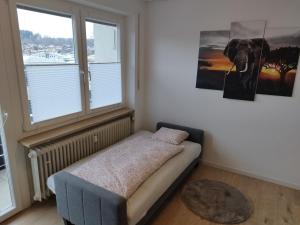 a bedroom with a bed and a large window at Kleine Wohlfühloase in Feldkirchen-Westerham
