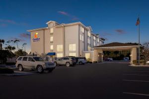 a hotel with cars parked in a parking lot at Comfort Inn & Suites Panama City - St Andrew in Panama City