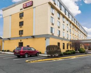 un coche rojo estacionado en un estacionamiento frente a un hotel en Clarion Hotel Somerset - New Brunswick, en Somerset