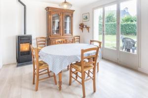 a dining room with a table and chairs and a stove at Tasmannia - 3 étoiles avec piscine chauffée - Erquy in Erquy