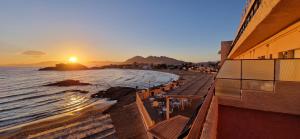 a view of a beach with the sun setting at Hotel Bahía by ALEGRIA in Puerto de Mazarrón +21 photos