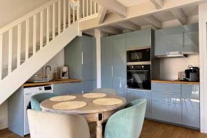 a kitchen with a table and chairs and a staircase at Le Cottage Détente in Biscarrosse