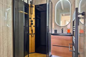 a bathroom with a wooden door and a mirror at Le Cottage Détente in Biscarrosse +16 photos