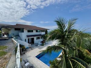 a house with a swimming pool and a palm tree at Long Beach Oceanview IL Villas Koh Lanta in Ko Lanta