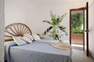 a bedroom with a blue and white bed with a plant at Vista Golfo 2 in Isola di Porticciuolo