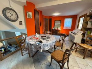 a dining room with a table and chairs and a clock at Maison à l'orée du bois in Frangy +6 photos