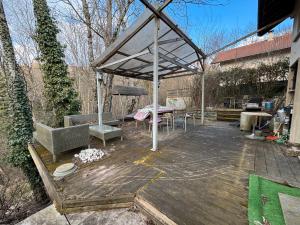 a wooden deck with a pavilion with a table and chairs at Maison à l'orée du bois in Frangy