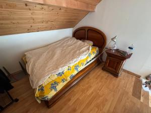 a bedroom with a bed and a night stand at Maison à l'orée du bois in Frangy
