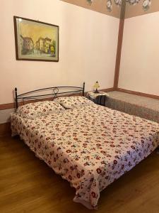 a bedroom with a bed with a floral bedspread at Appartamento Giallo in Rio Marina