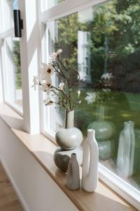 ギュータースローにあるVilla am Stadtpark - Boardinghouseの白花瓶3本の窓枠