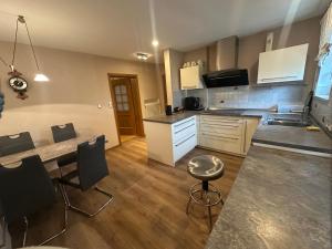 a kitchen with white cabinets and a table and chairs at Apartment with top kitchen and 3 sleeping rooms in Untermeitingen