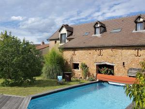 a house with a swimming pool in front of a house at La Parenthèse à Etrigny in Étrigny