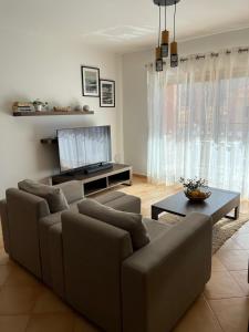 a living room with a couch and a table at Margarida Apartment in Luz