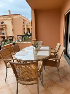 a table and chairs on a balcony with a view of a building at Margarida Apartment in Luz
