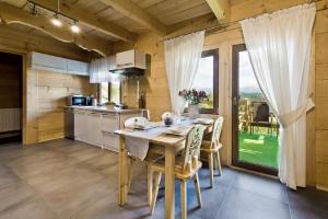 a kitchen and dining room with a table and chairs at Domki GliczarowSKI z Jacuzzi & Sauna in Zakopane