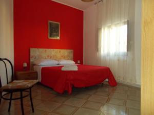 - une chambre rouge avec un lit avec un mur rouge dans l'établissement Zia Silvana Apartment, à Trapani