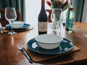 a wooden table with a bowl and a bottle of wine at Pass the Keys Spacious and Comfortable 3 Bed Home in Birkenhead in Birkenhead