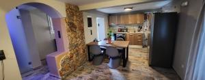 a kitchen with a table and a stone wall at Oinos Luxury apartment in Faliraki +6 photos