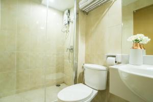 y baño con aseo, ducha y lavamanos. en Beyond Suite, en Bangkok