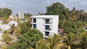 芭环礁卡马德霍岛伊特哈旅馆的树木中间带阳台的白色建筑