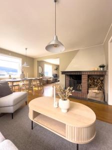 a living room with a table and a fireplace at Stor innbydende leilighet med 4 soverom og sentral beliggenhet in Notodden
