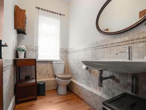 a bathroom with a sink and a toilet and a mirror at Pass the Keys Spacious and Comfortable 3 Bed Home in Birkenhead in Birkenhead