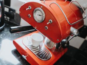an orange coffee machine with a cup on aucer at Pass the Keys Spacious and Comfortable 3 Bed Home in Birkenhead in Birkenhead