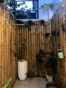 a wooden fence with a white vase with plants in it at Entire House inside Residential Area, Banilad Cebu in Cebu City