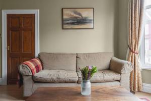 a living room with a couch and a table at Pass the Keys Spacious and Comfortable 3 Bed Home in Birkenhead in Birkenhead