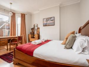 a bedroom with a large bed and a desk at Pass the Keys Spacious and Comfortable 3 Bed Home in Birkenhead in Birkenhead