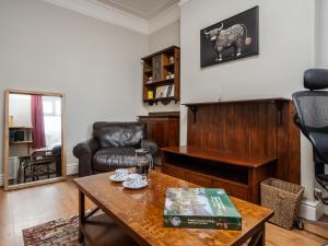 a living room with a table and a couch at Pass the Keys Spacious and Comfortable 3 Bed Home in Birkenhead in Birkenhead