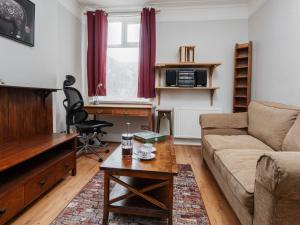 a living room with a couch and a desk at Pass the Keys Spacious and Comfortable 3 Bed Home in Birkenhead in Birkenhead