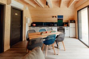 a kitchen with a wooden table and chairs at LES CHALETS DE COYRON. in Coyron