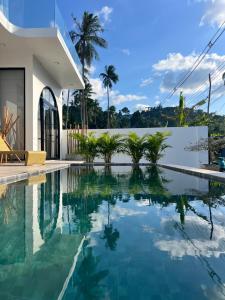 een zwembad voor een huis met palmbomen bij The Brova villa- Beautiful Private 3 bedroom villa in Nathon Bay