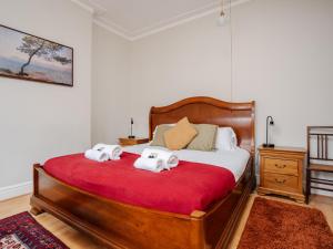 a bedroom with a large bed with towels on it at Pass the Keys Spacious and Comfortable 3 Bed Home in Birkenhead in Birkenhead