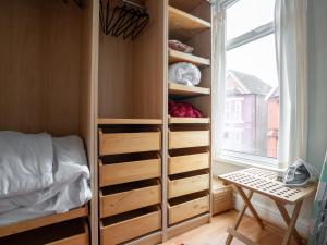 a bedroom with a closet with a bed and a window at Pass the Keys Spacious and Comfortable 3 Bed Home in Birkenhead in Birkenhead