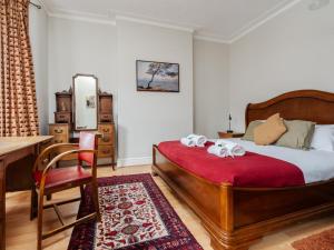 a bedroom with a bed and a desk and a table at Pass the Keys Spacious and Comfortable 3 Bed Home in Birkenhead in Birkenhead