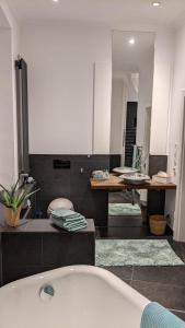 a bathroom with a tub and a table and a mirror at Haus Forst Schlossblick Phantasialand Köln Bonn in Brühl