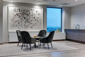 a waiting room with chairs and a table and a painting at Clarion Hotel Air in Sola