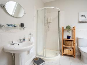 a white bathroom with a shower and a sink at Pass the Keys Spacious and Comfortable 3 Bed Home in Birkenhead in Birkenhead